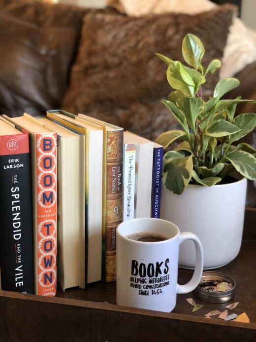 Books, Coffee, and a plant with couch in the background