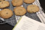 Chocolate Chip Cookies on a cooling rack next to a cookbook