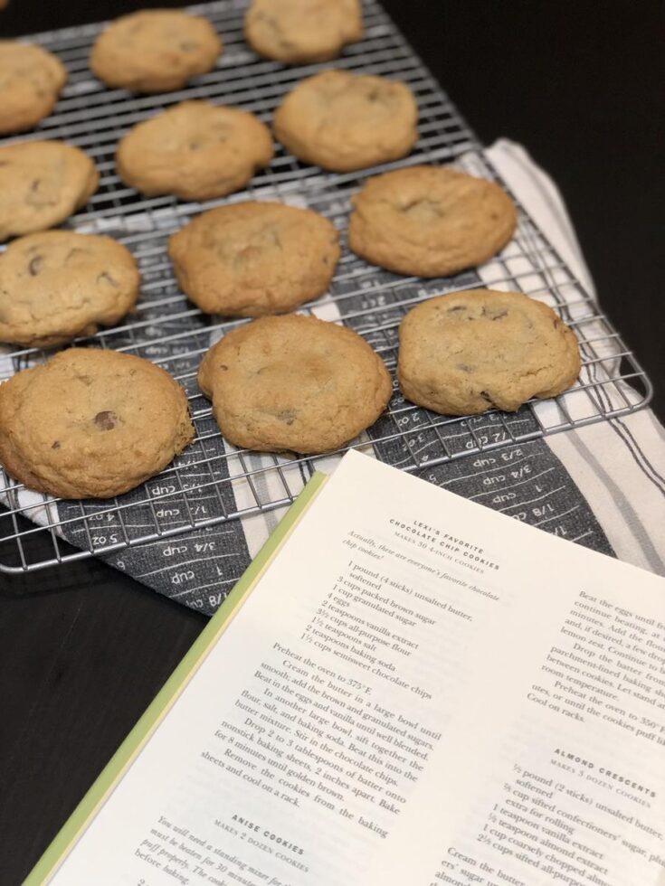 Chocolate Chip Cookies on a cooling rack next to a cookbook