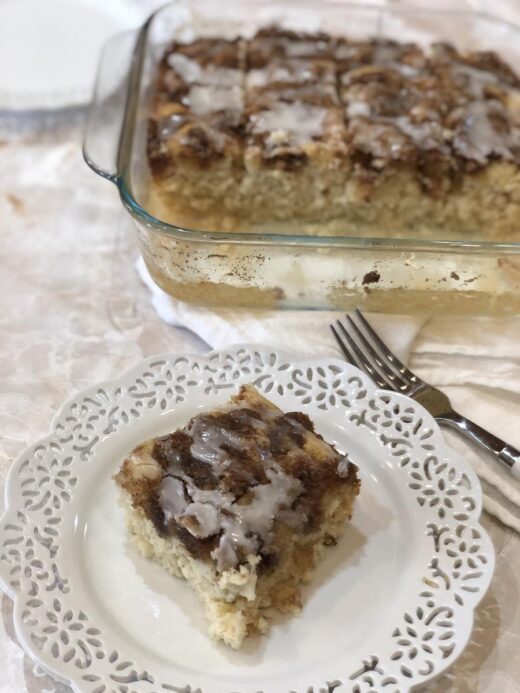 Cinnamon Roll Muffin Cake Gluten Free on white plate with cake in background