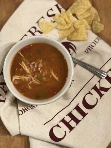 Mexican Chicken Rice Soup in bowl with spoon and tortilla chips
