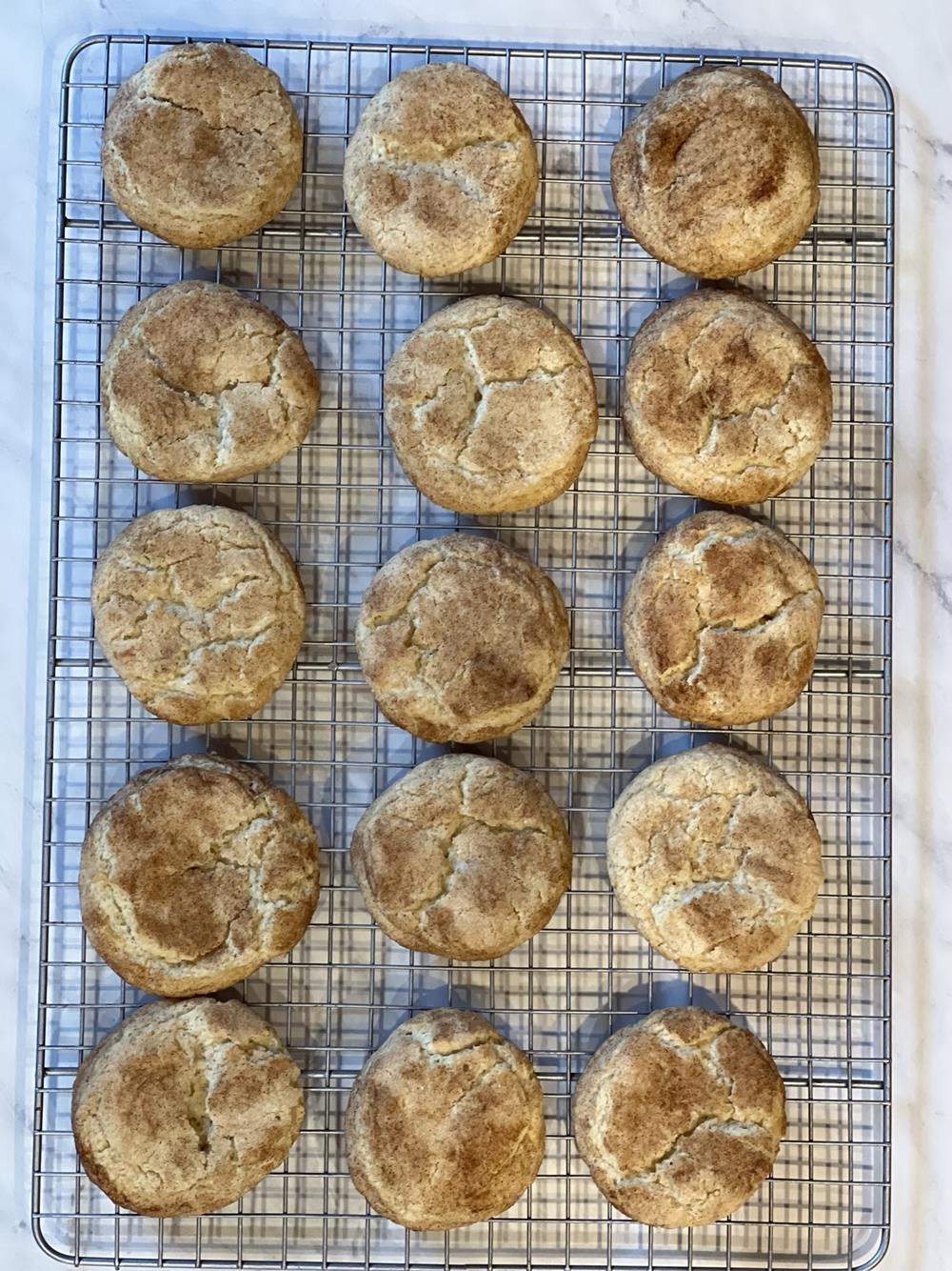 Snickerdoodles on wire cooling rack and white marble background