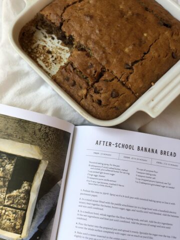 banana bread in a pan with cookbook