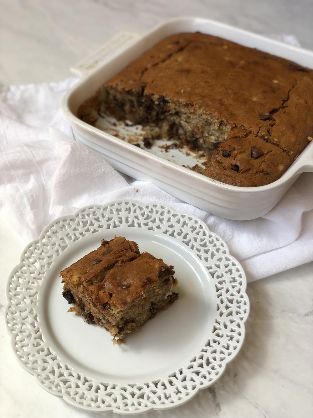 Joanna Gaines gluten free banana bread in white pan with piece on white plate