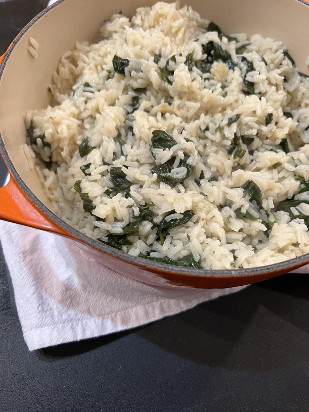 rice and spinach in pot on black counter