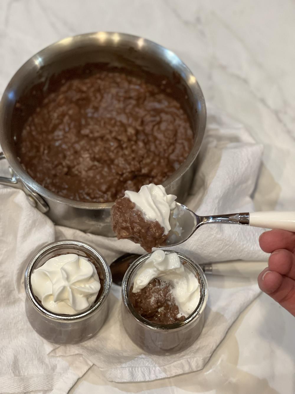 Chocolate rice pudding in pan and also glass dish with spoon