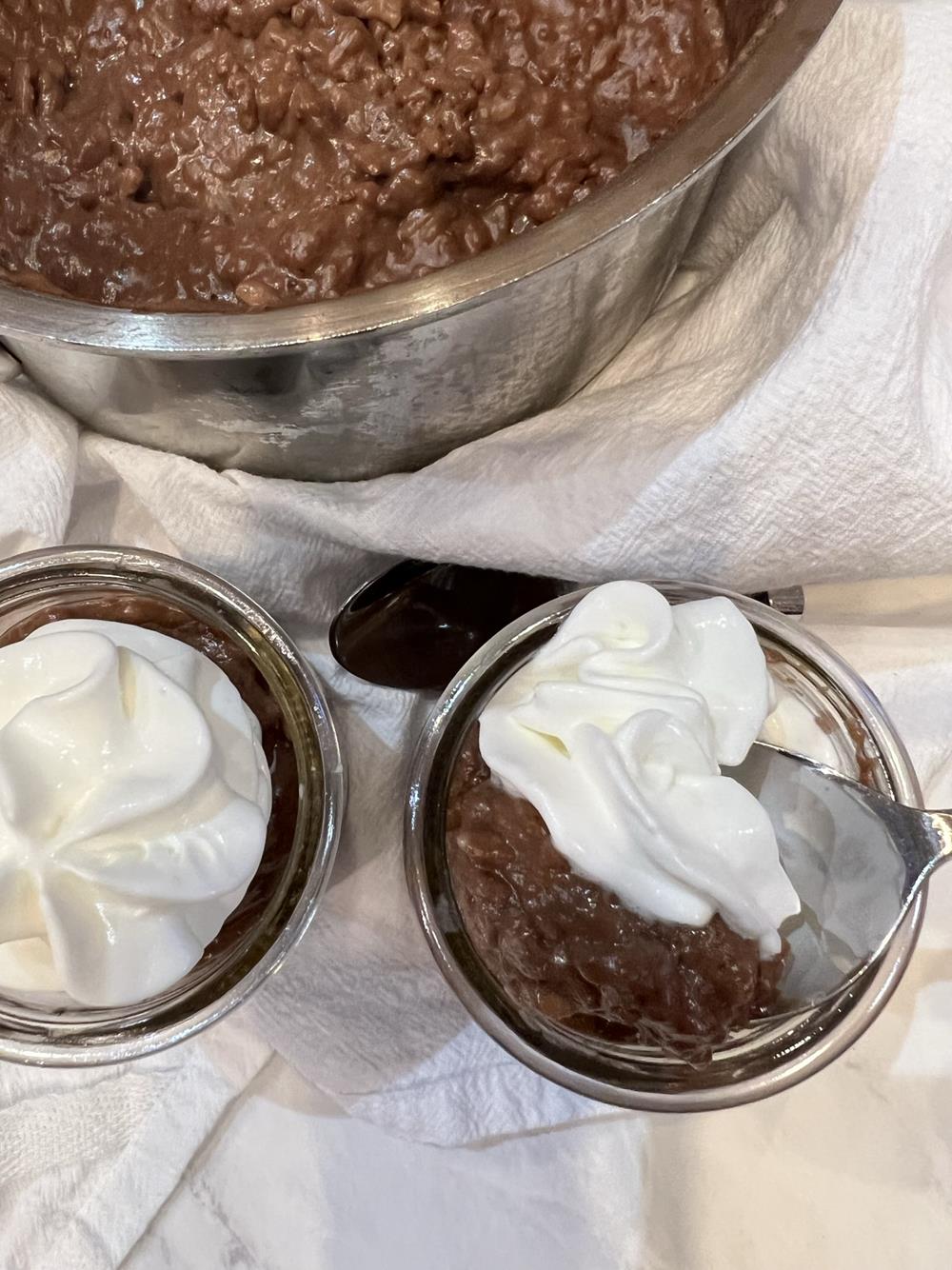 Chocolate Rice Pudding with whipped cream and pan in background