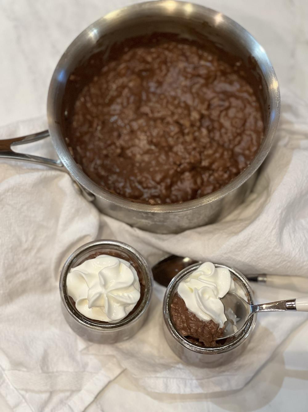 Chocolate rice pudding in bowl with whipped cream