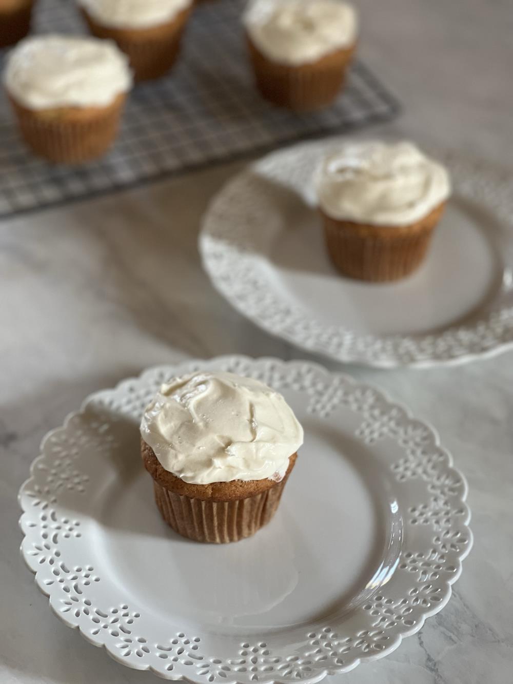 banana cupcakes with frosting on white plate