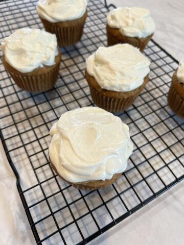 banana cupcakes with frosting on cooling rack