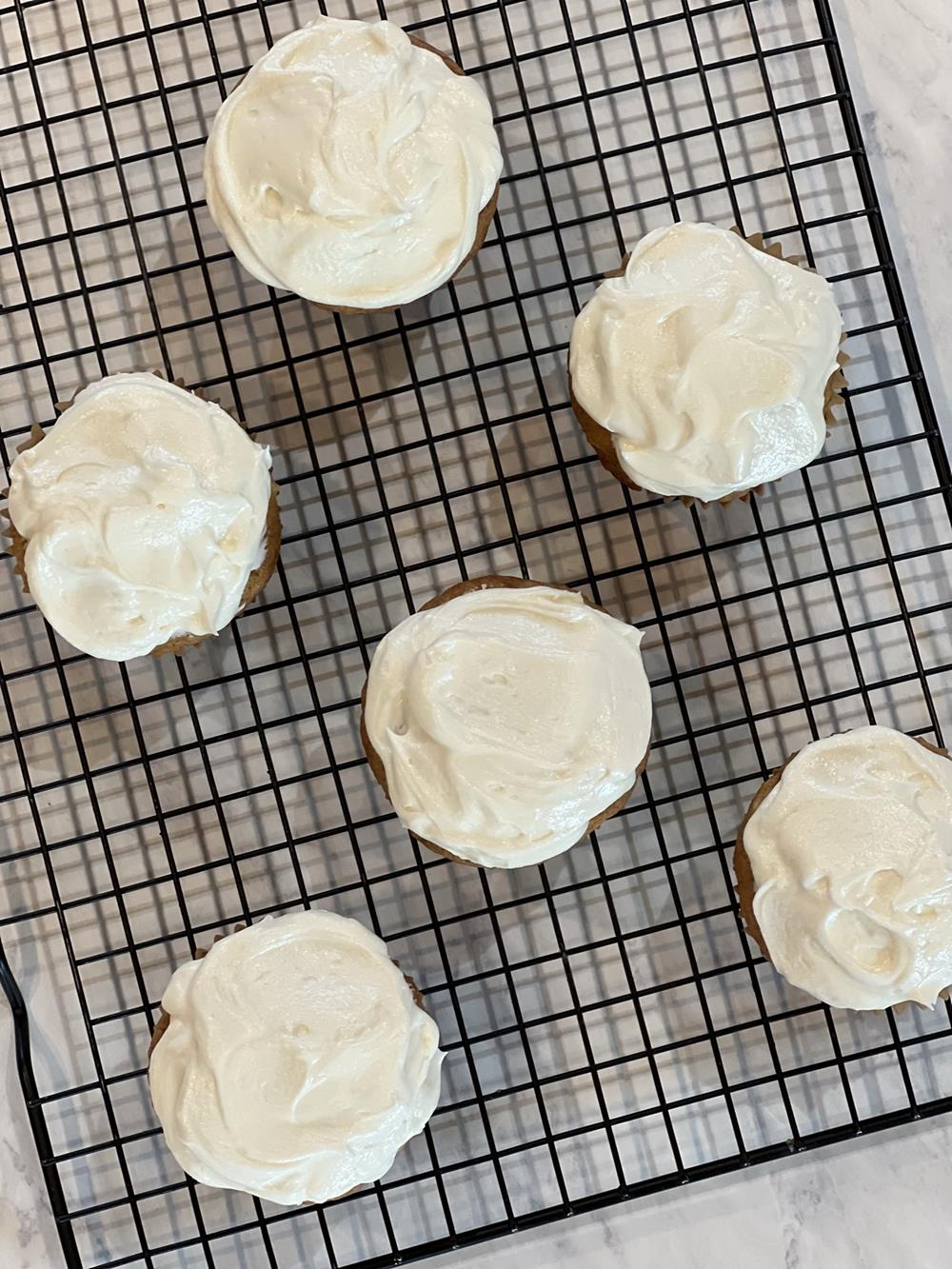 banana cupcakes with frosting on cooling rack