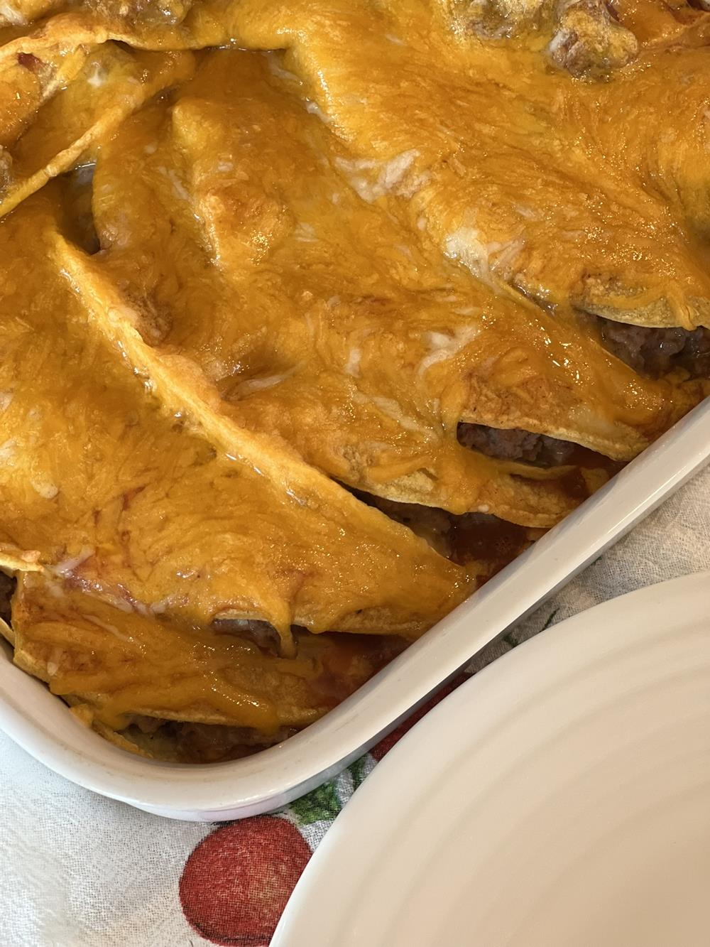 Enchiladas in white casserole dish