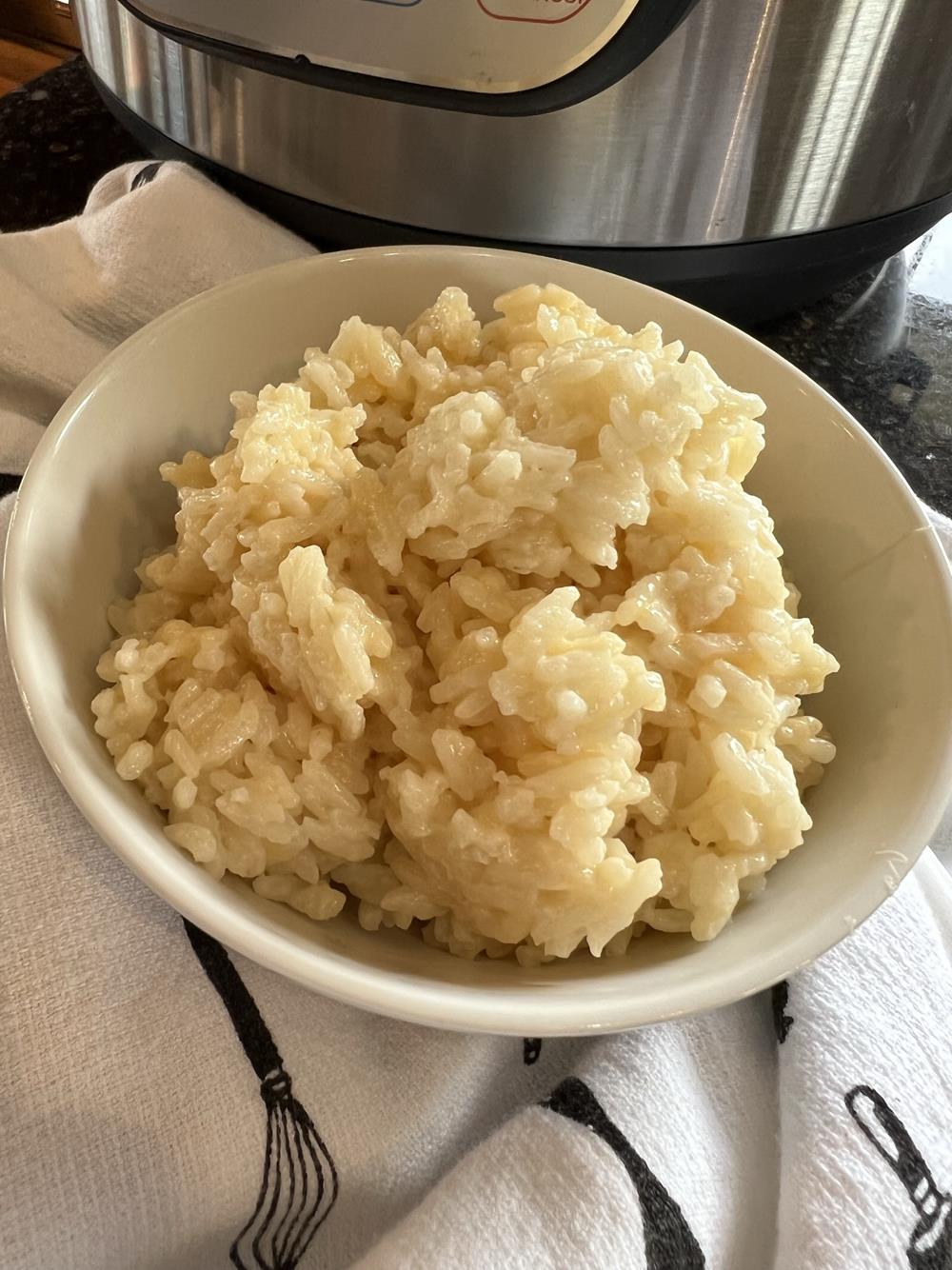 cheese rice in a white bowl with Instant Pot in background