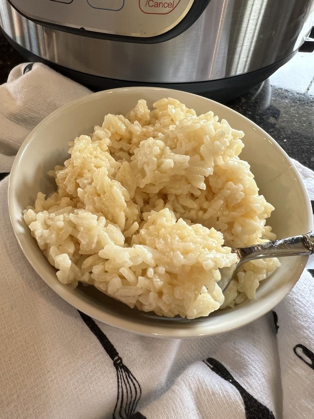 cheese rice in a white bowl with spoon
