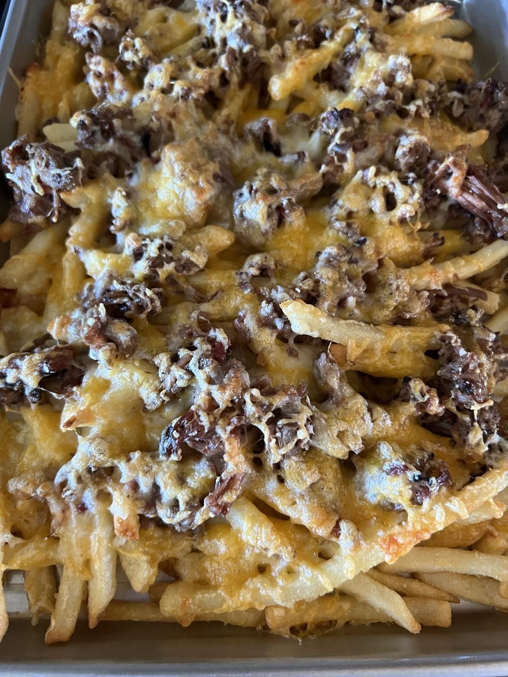 fries, bbq meat, and cheese on baking sheet