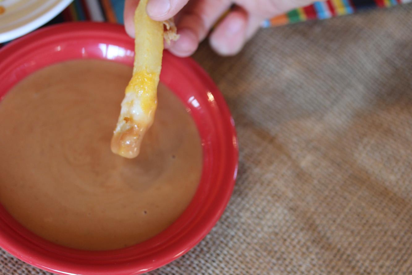 Fries and sauce in red bowl