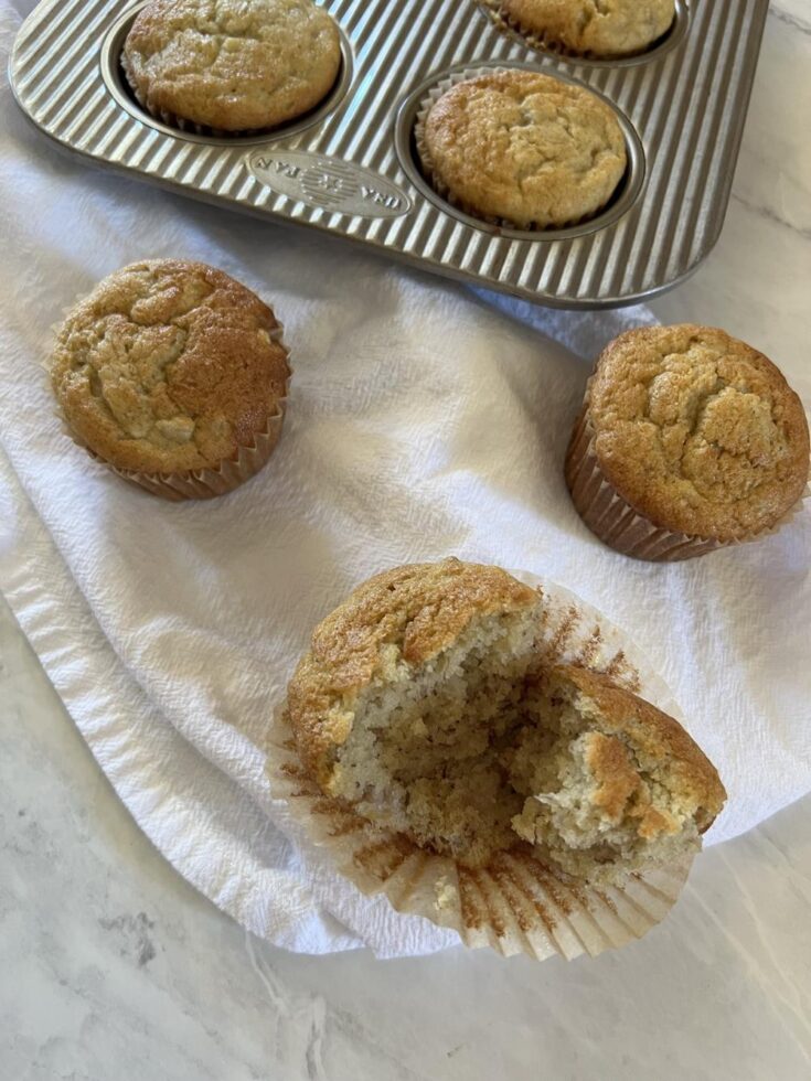 banana muffins on white napkin with muffin pan in backgroundB