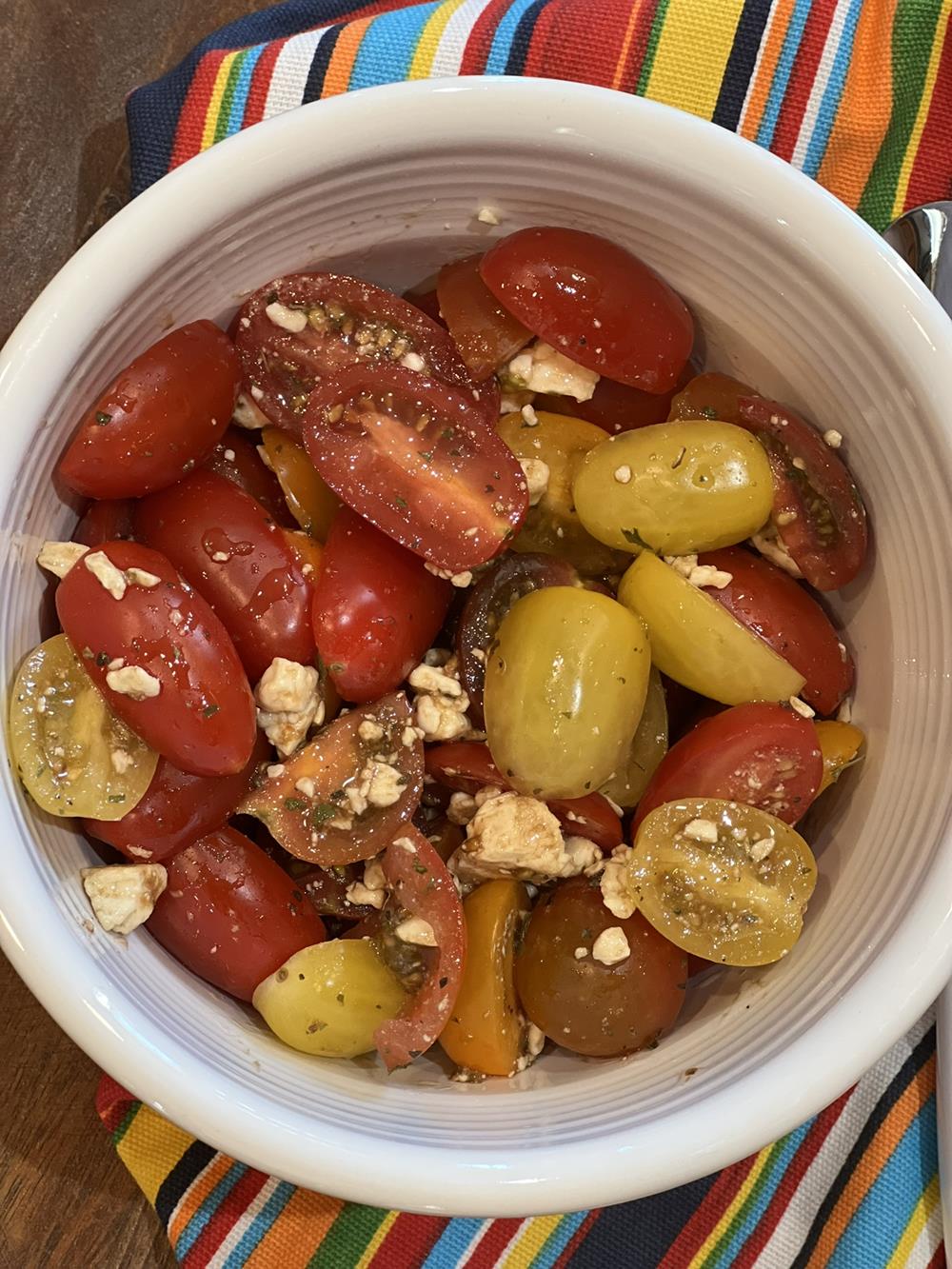 tomato salad with white bowl with striped napkin