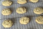 lemon white chocolate cookies on cooling rack and cookie sheet
