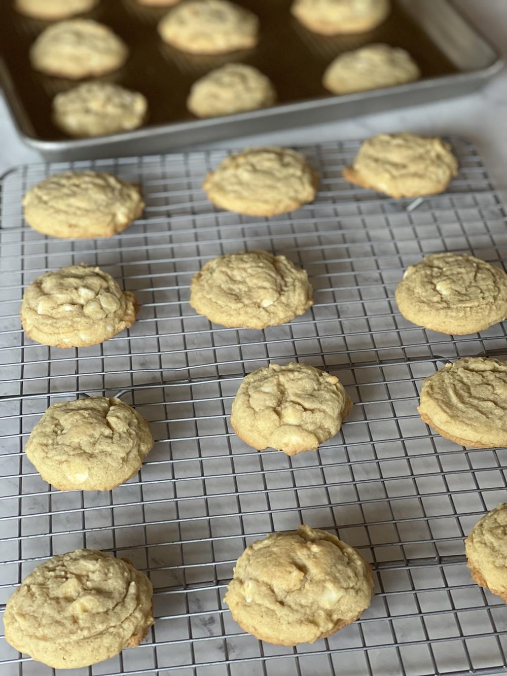 lemon white chocolate cookies on cooling rack and cookie sheet