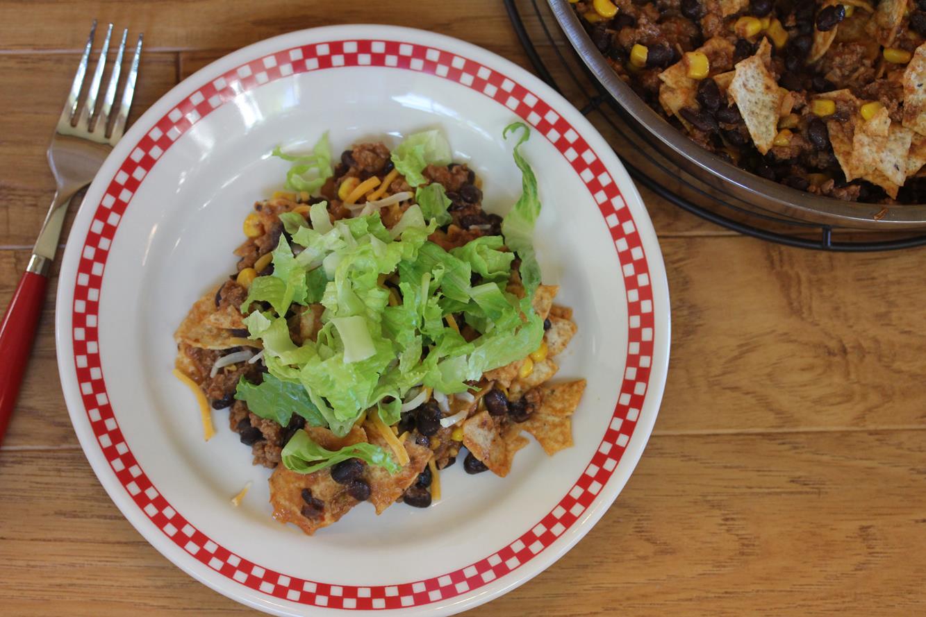 Taco dinner on white and red plate with red handled fork