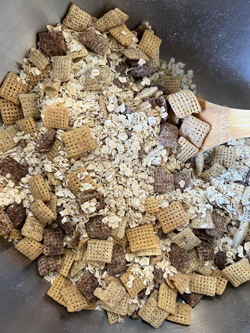 chex cereal and oatmeal in a bowl with wooden spoon