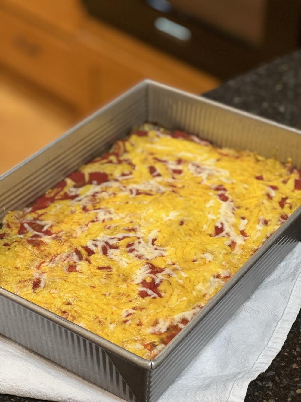 relleno casserole with cheese in metal baking pan