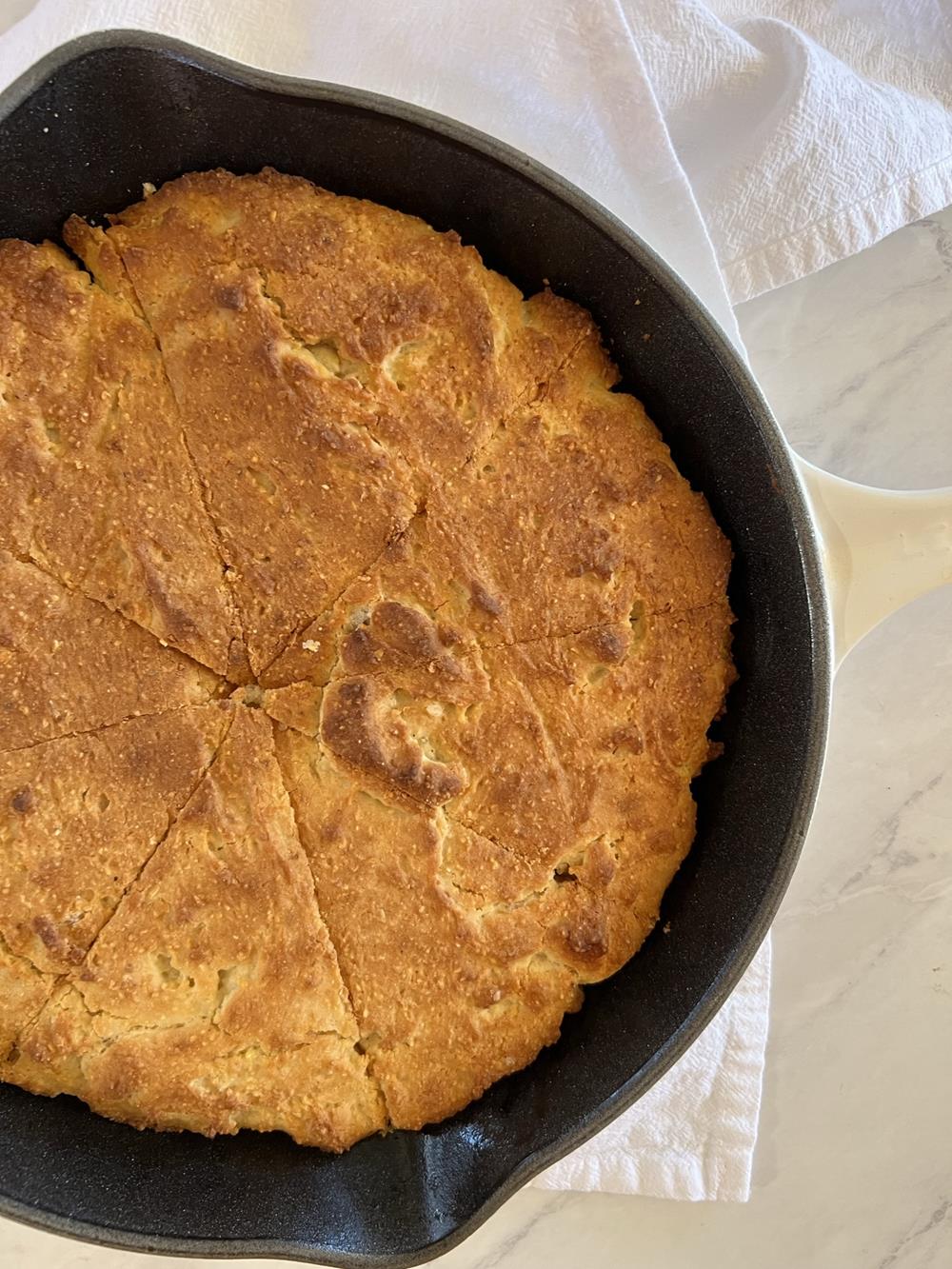 cornbread in pan on white kitchen towel