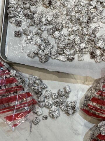 candy cane chex mix on cookie sheet with bags of it place in front