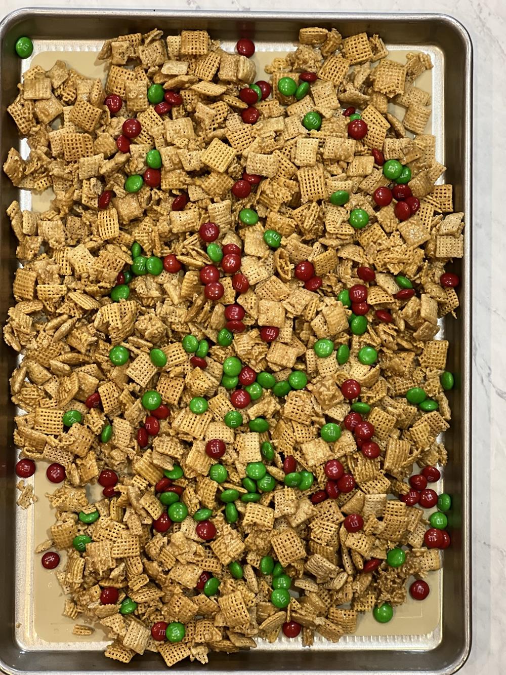 caramel chex mix with m&m's on cookie sheet