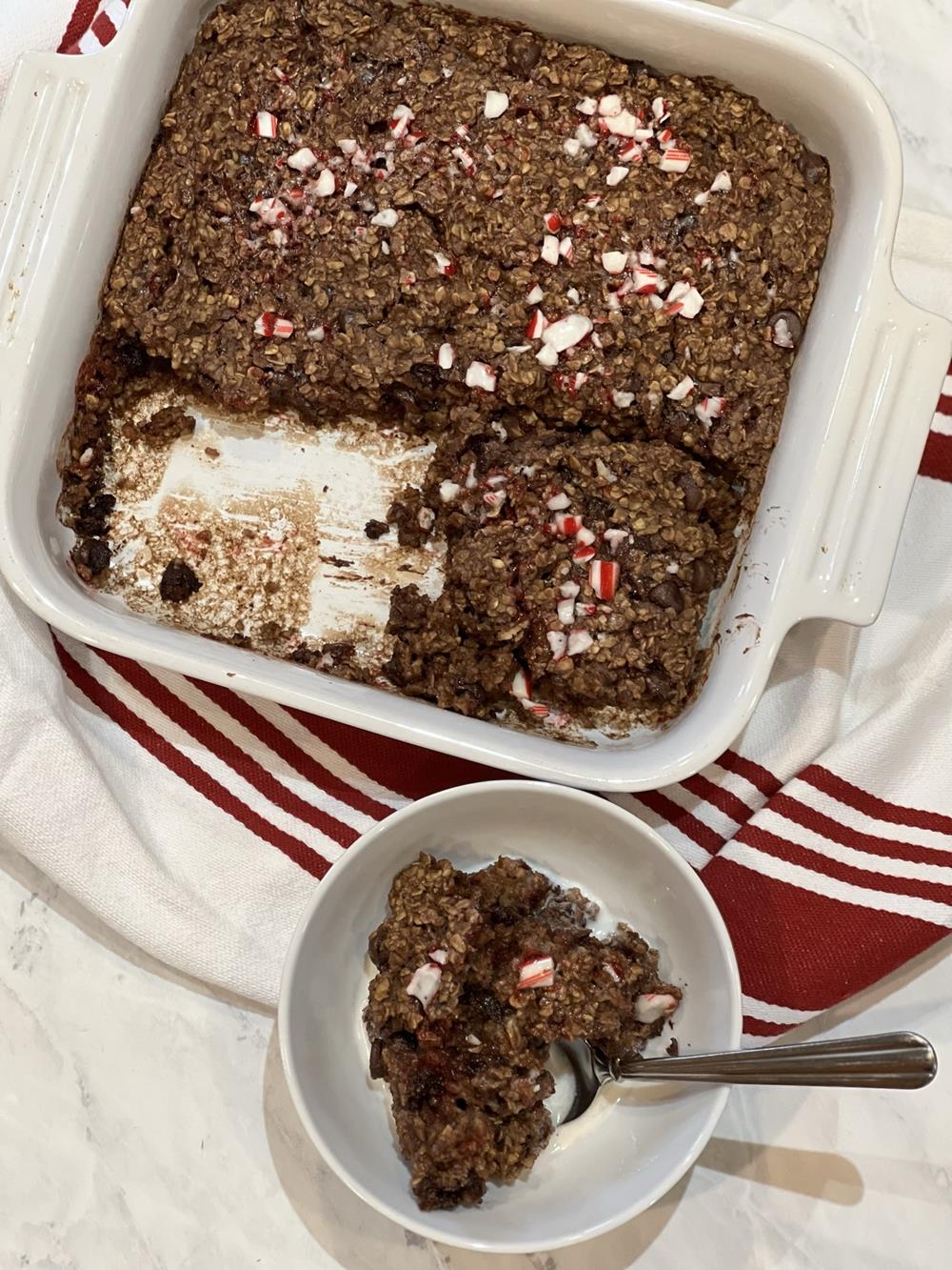 chocolate candy cane baked oatmeal in a white bowl with milk on top