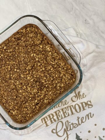 gingerbread baked oatmeal in glass dish with napkin in background