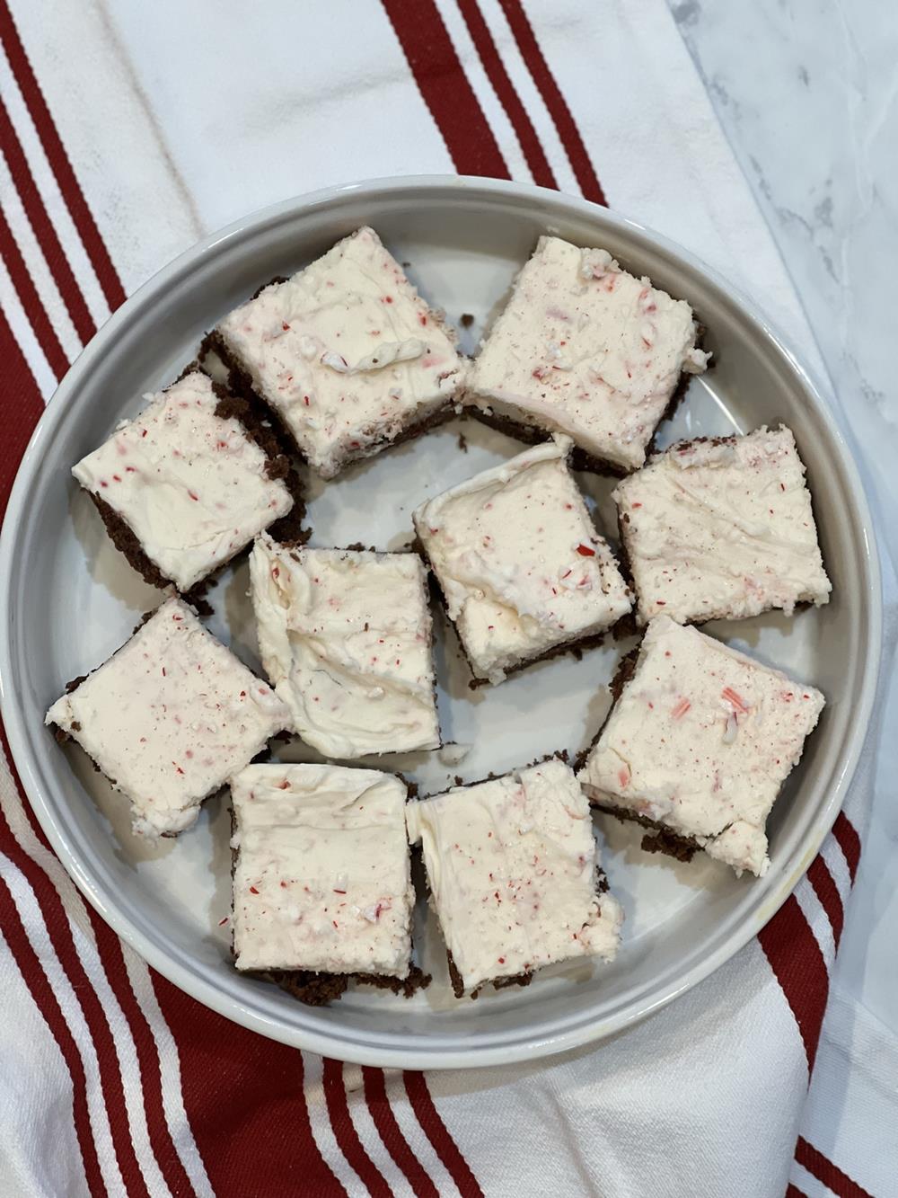 brownie's with frosting in white dish