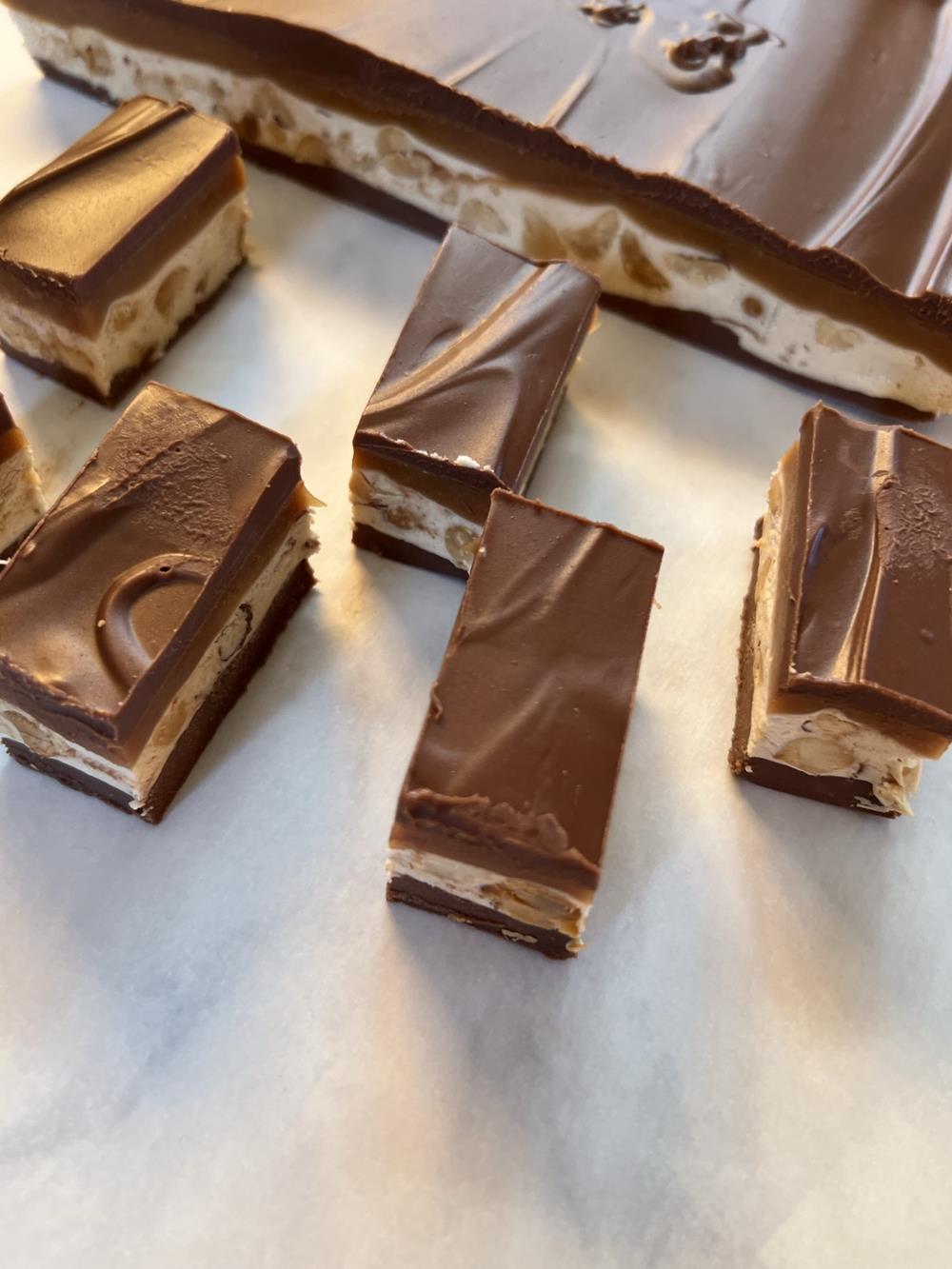 homemade snickers bars cut on white background