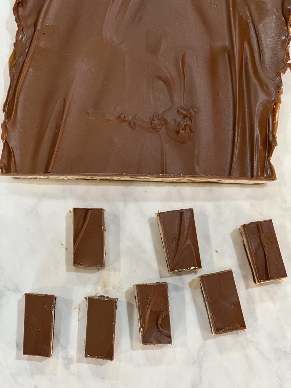 homemade snickers bars cut into pieces on white background
