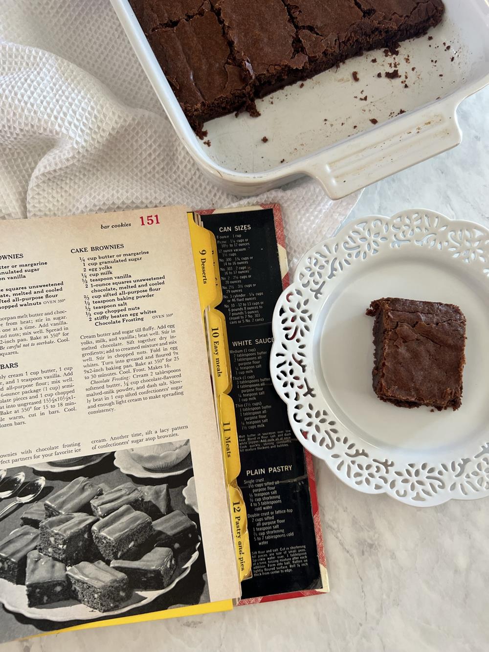 Cookbook, and a brownie on a white plate