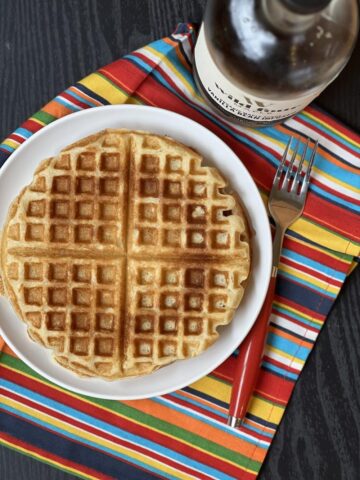waffles on white plate and a striped napkin