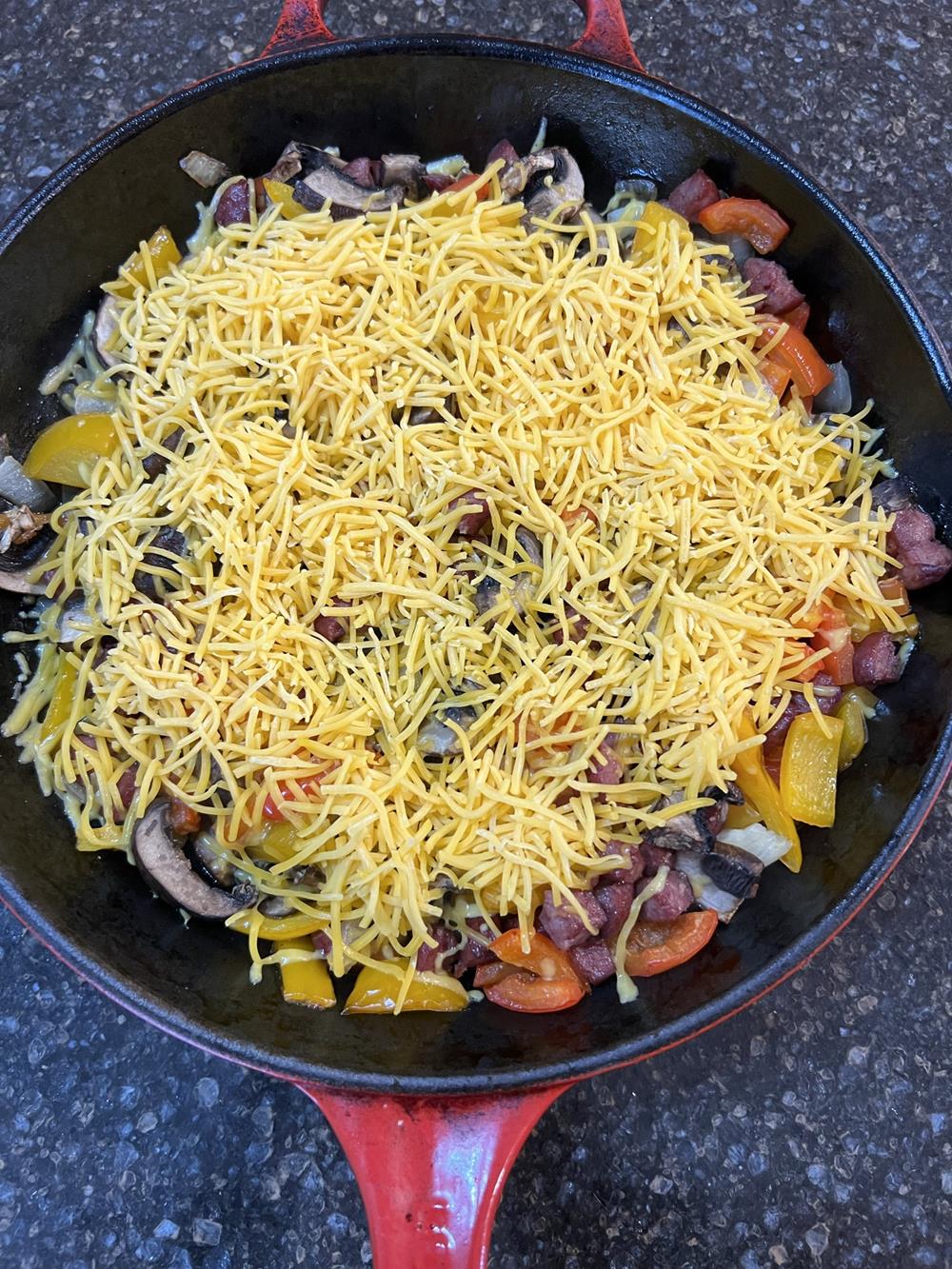 vegatbles and cheese in red skillet