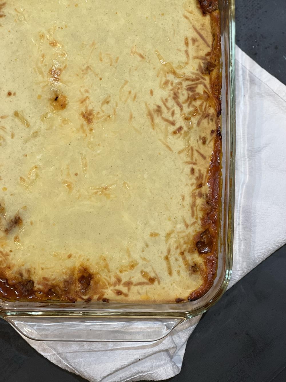 baked pizza casserole in a pan on a white towel