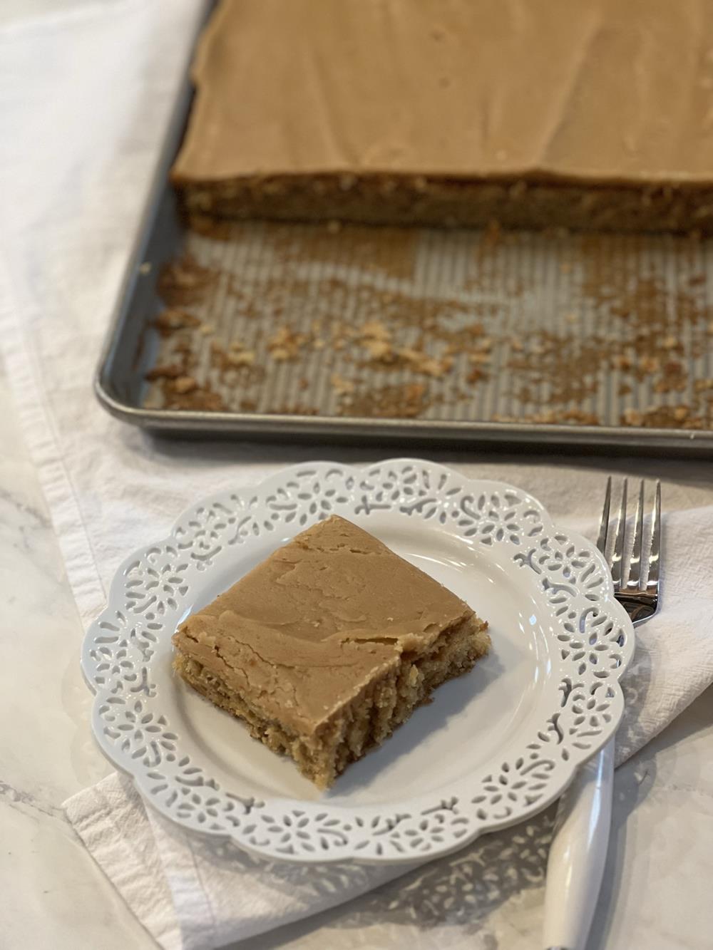 Peanut Butter Sheet Cake Gluten Free on white plate with cake pan in background