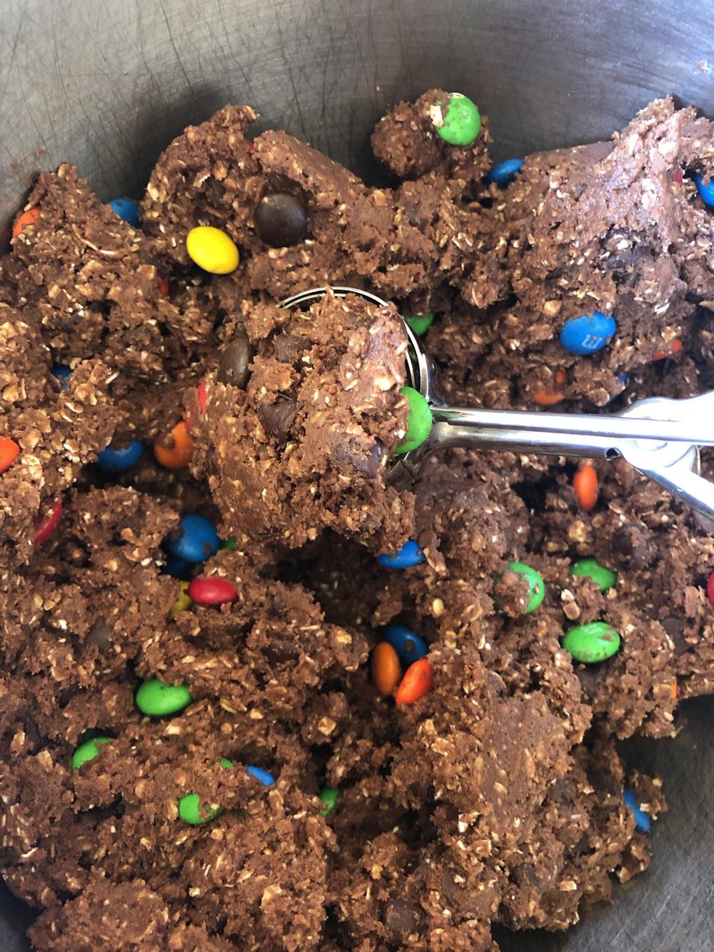 chocolate oatmeal cookie dough with M&Ms in a mixing bowl