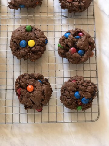 Chocolate Cowboy Cookies with M&M's on cooling rack