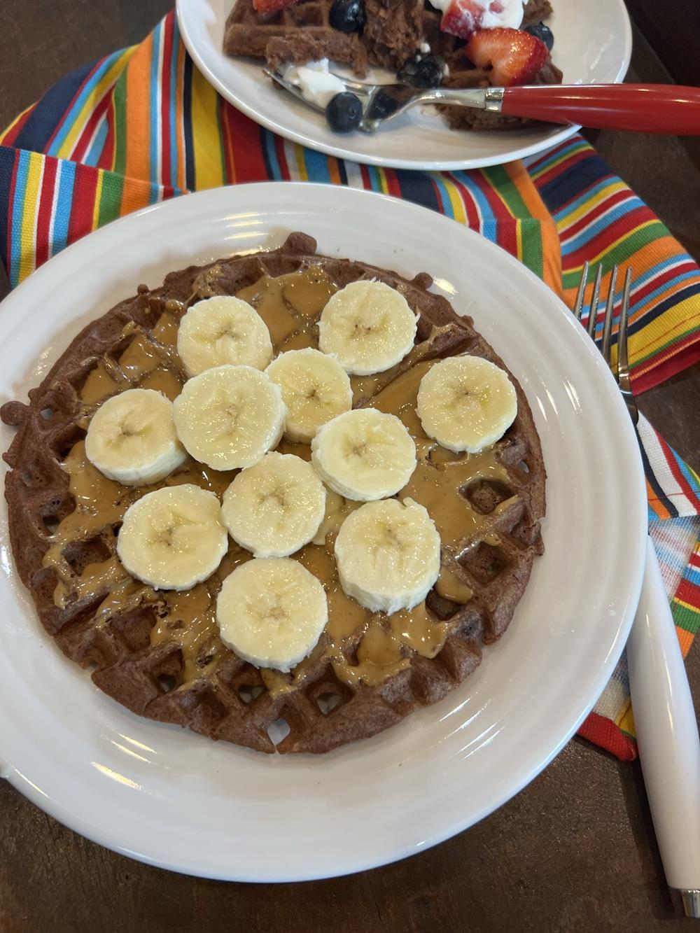 chocolate waffles with bananas on white plate