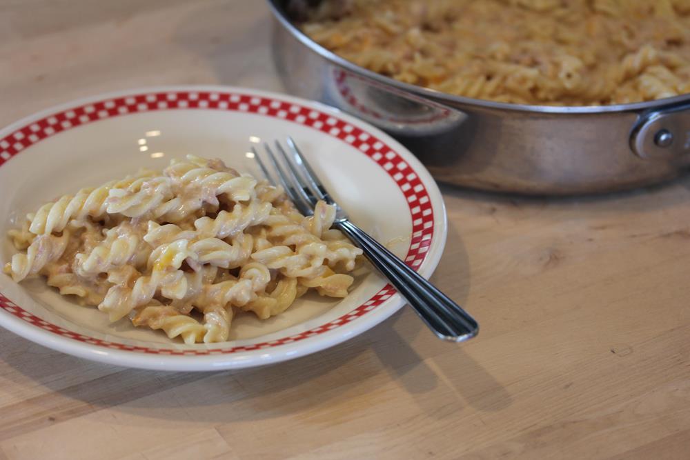 Homemade Tuna Helper in skillet with a red and white plate in front of the pan.