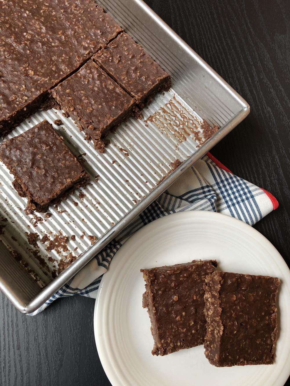 No bake cookie bars in metal pan and two bars on white plate