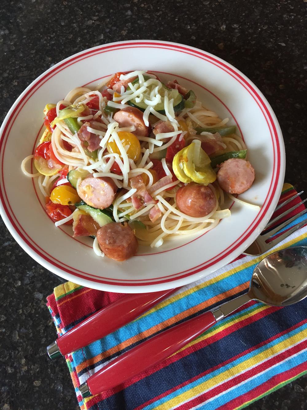 Pasta with Roasted Vegetables and Sausage on a red and white plate