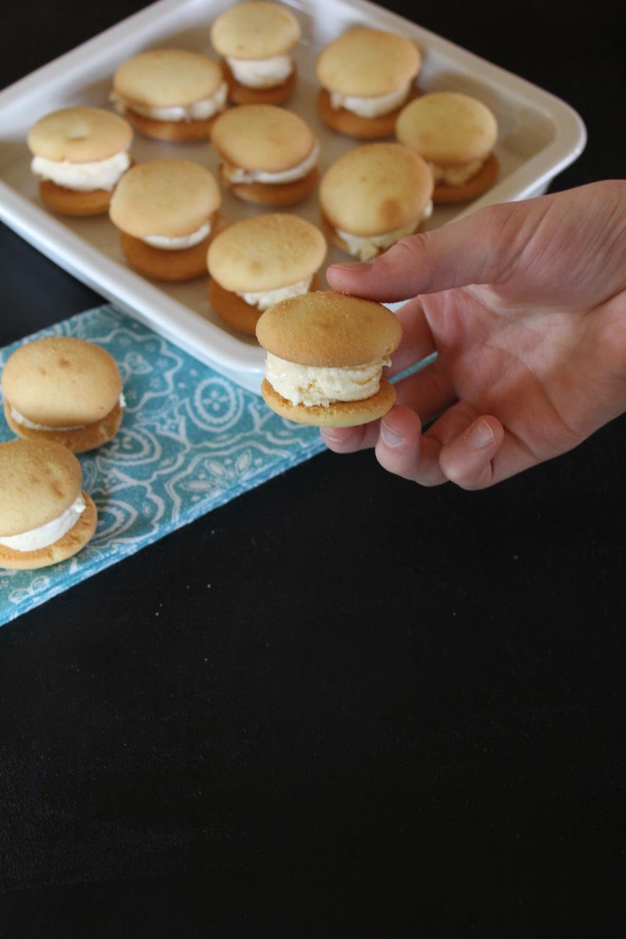 vanilla wafer ice cream sandwich with a white plate in background.