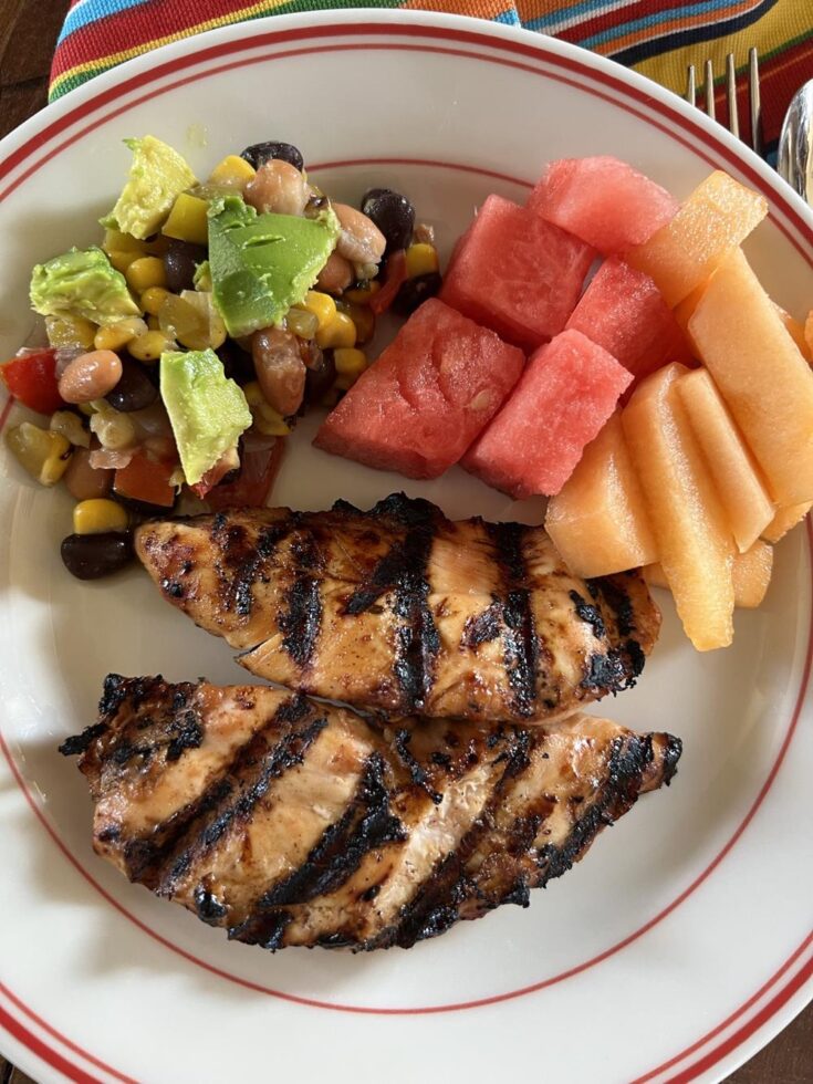 bbq ranch chicken tenders on a plate with melon and salad