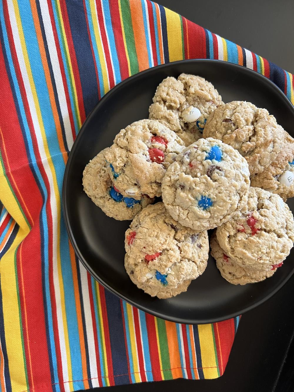 Oatmeal cookies on black plate with striped napkin