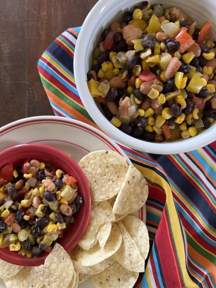 Corn, bean, dip in white bowl with chips